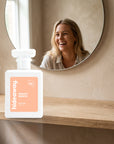hideaway. Peachy Nights perfume 50ml bottle on an oak shelf below a round mirror