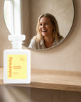 hideaway. Chasing Sunlight perfume 50ml bottle on an oak shelf below a round mirror