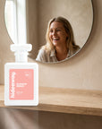 hideaway. Blossom Breeze perfume 50ml bottle on an oak shelf below a round mirror