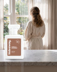 hideaway. Vanilla Coconut perfume 50ml bottle on a marble ledge by a sunlit window