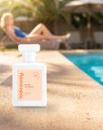 hideaway. Main Squeeze perfume 50ml bottle on a sunlit pool ledge on a summer afternoon