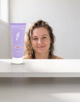 hideaway. Mini Black Essence Shower Mousse on a white shelf in a bright tiled bathroom
