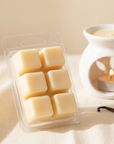 hideaway. Vanilla Caramel wax melts pack of six creamy wax cubes beside a lit white ceramic wax melt burner