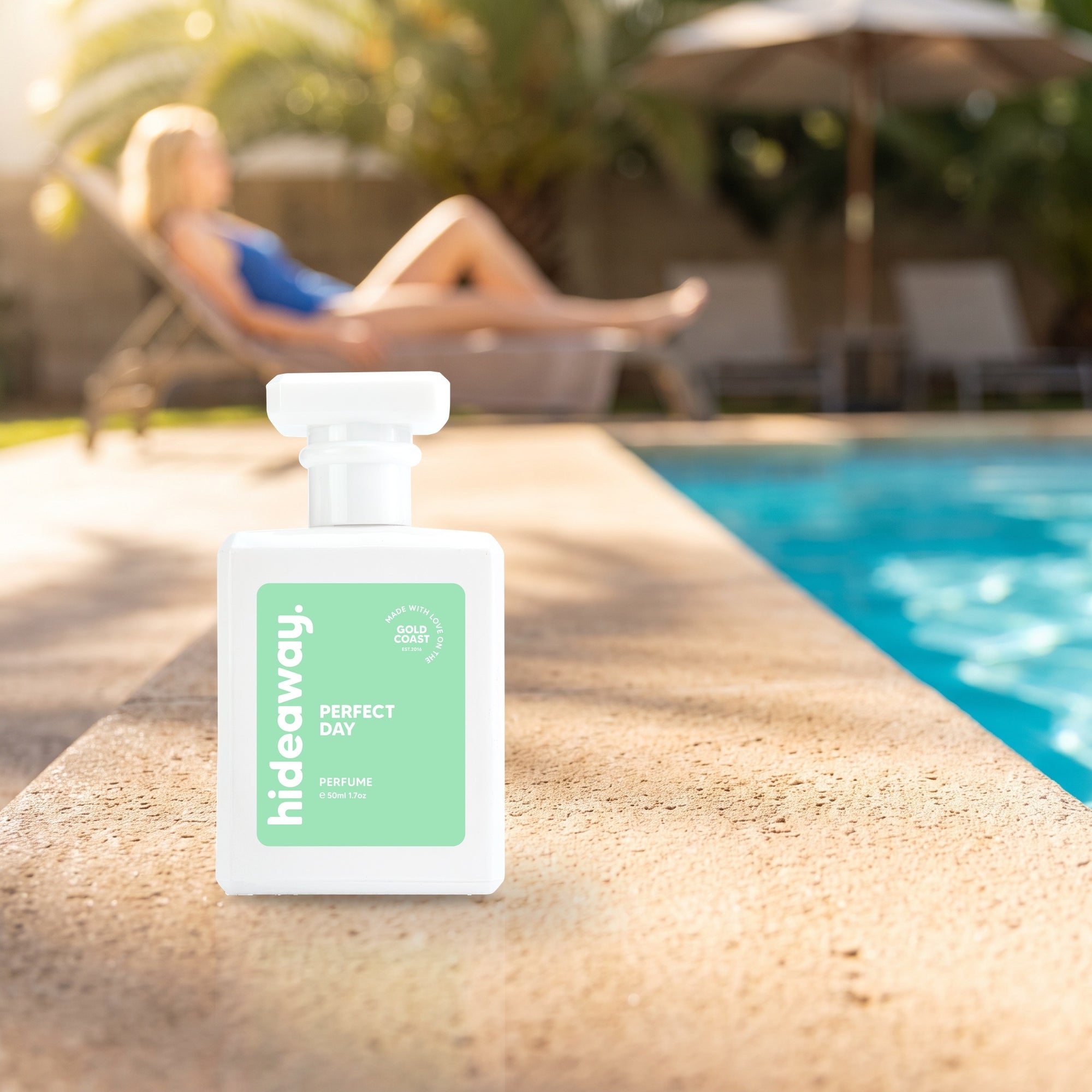 hideaway. Perfect Day perfume 50ml bottle on a sunlit pool ledge on a summer afternoon