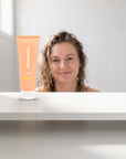 hideaway. Pineapple Coconut Conditioner on a white shelf in a bright tiled bathroom