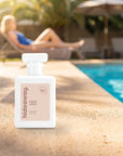 hideaway. Coco Loco perfume 50ml bottle on a sunlit pool ledge on a summer afternoon