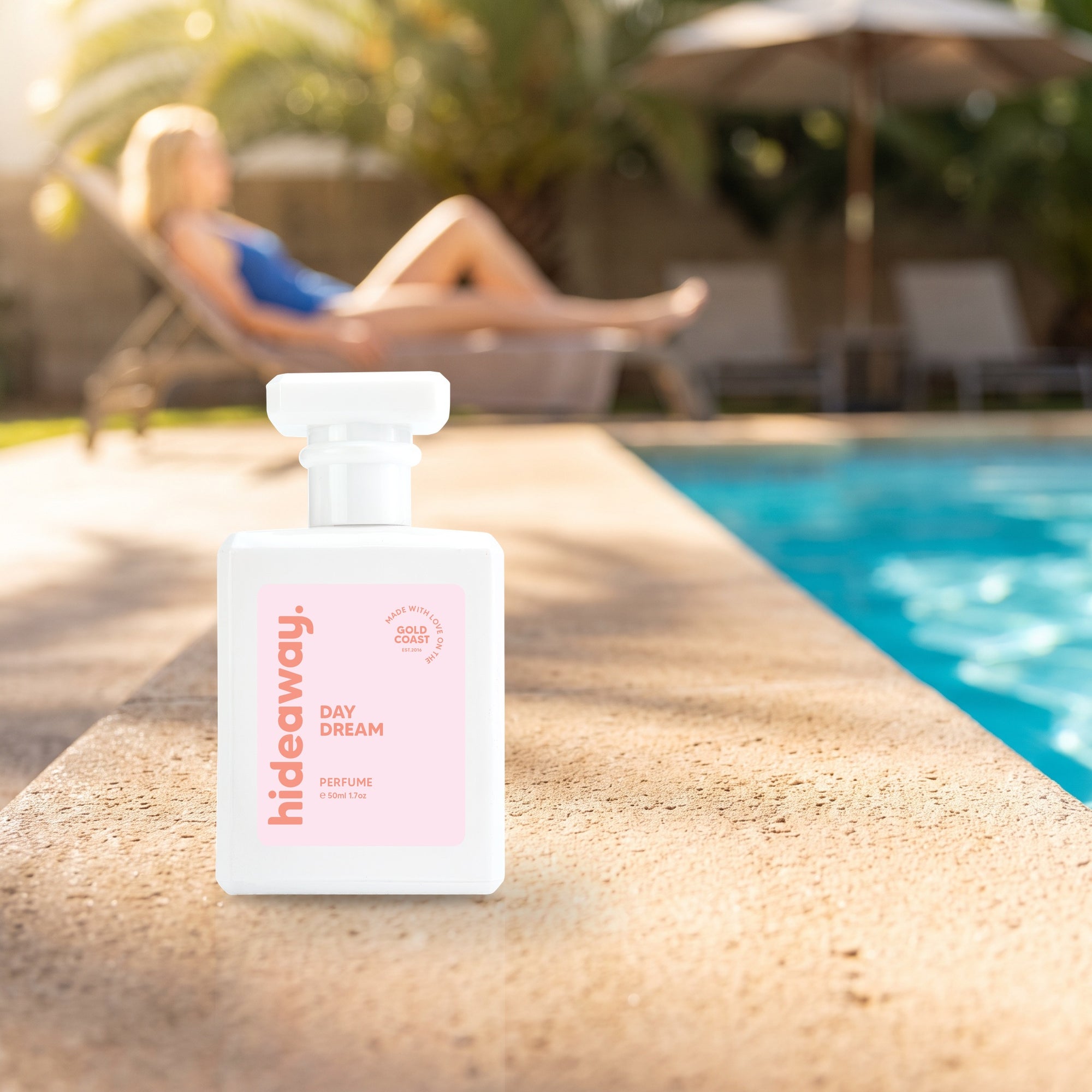 hideaway. Day Dream perfume 50ml bottle on a sunlit pool ledge on a summer afternoon