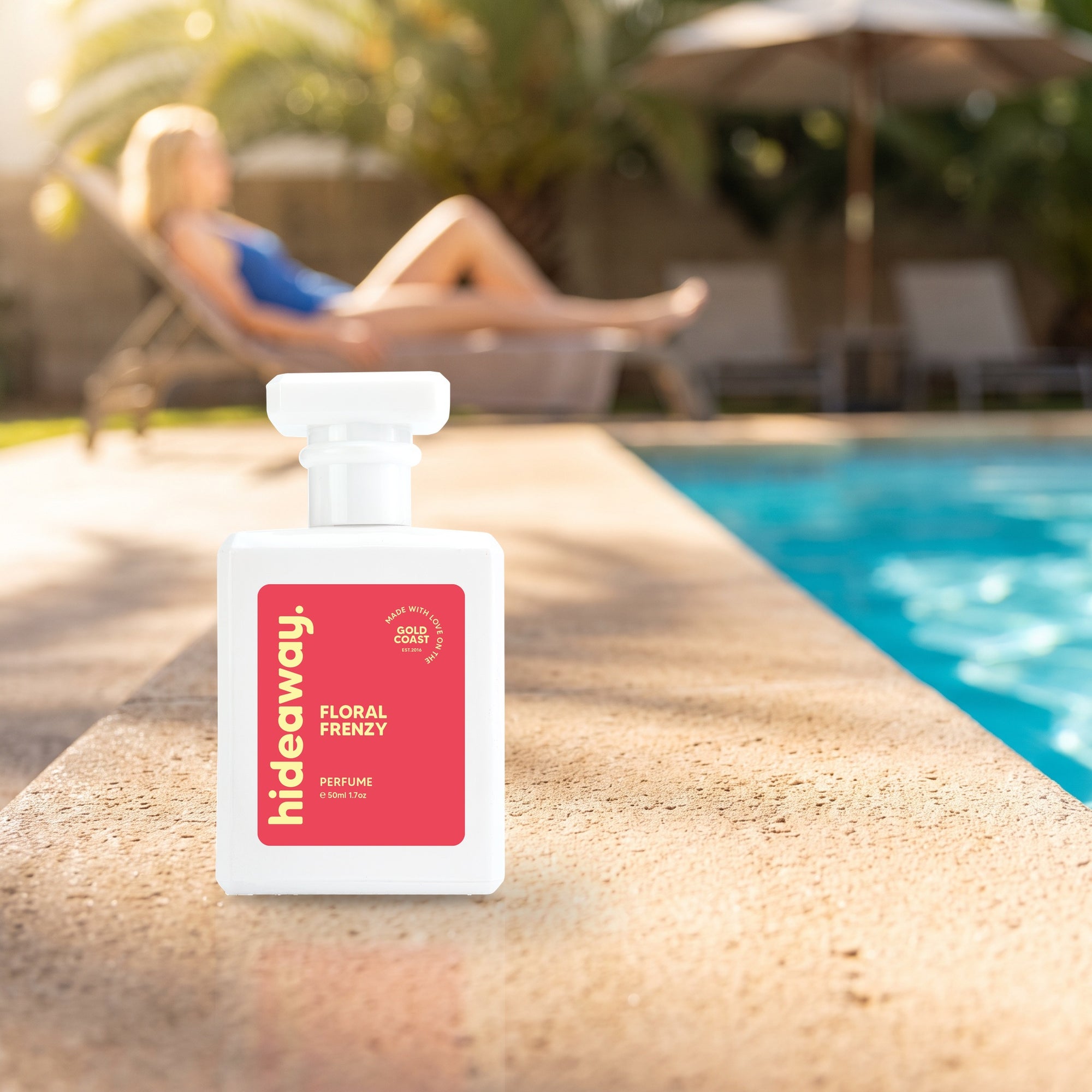 hideaway. Floral Frenzy perfume 50ml bottle on a sunlit pool ledge on a summer afternoon