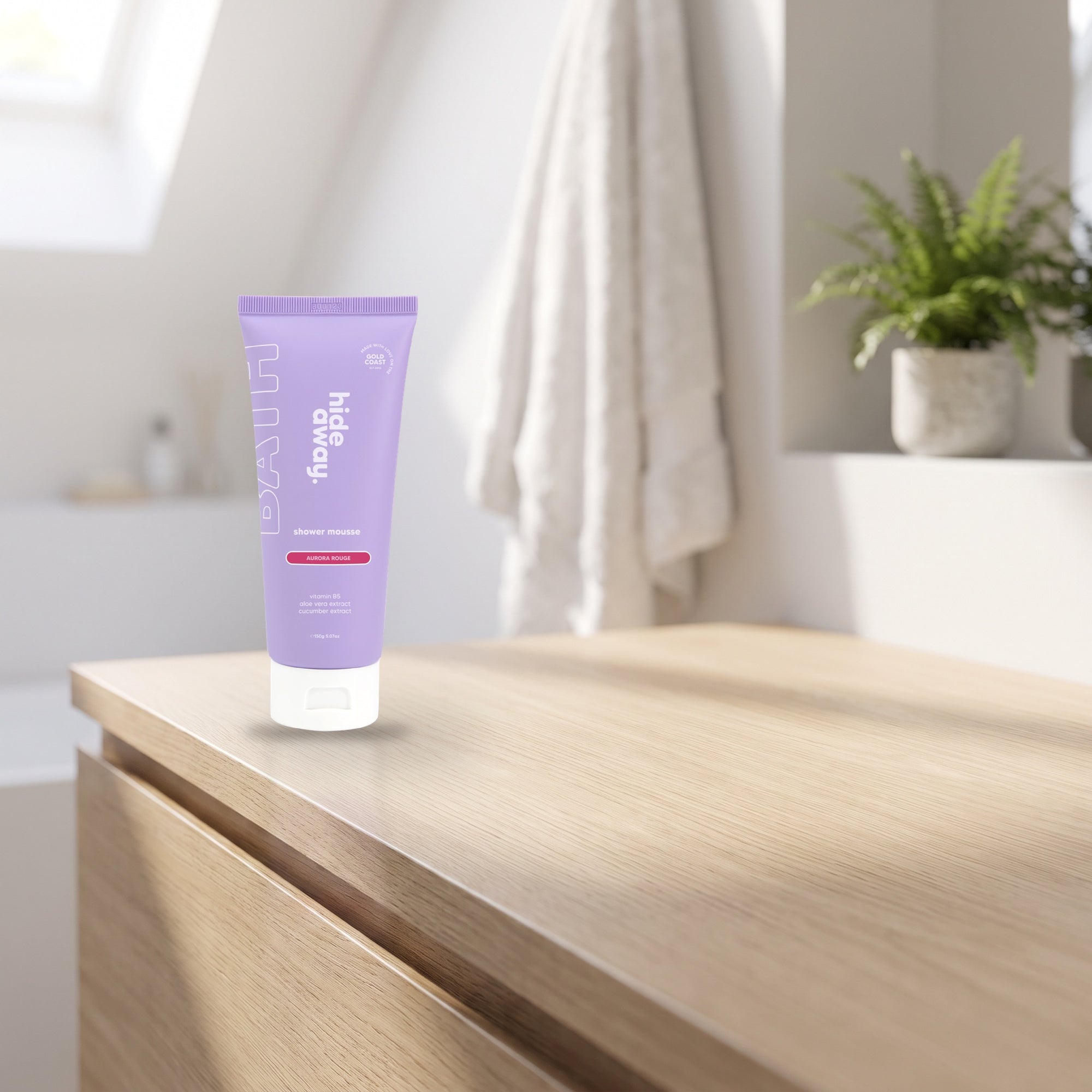 hideaway. Mini Aurora Rouge Shower Mousse on a pale timber vanity top in a bright bathroom