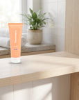 hideaway. Mini Black Essence Shampoo on a timber bathroom shelf beside rolled towels