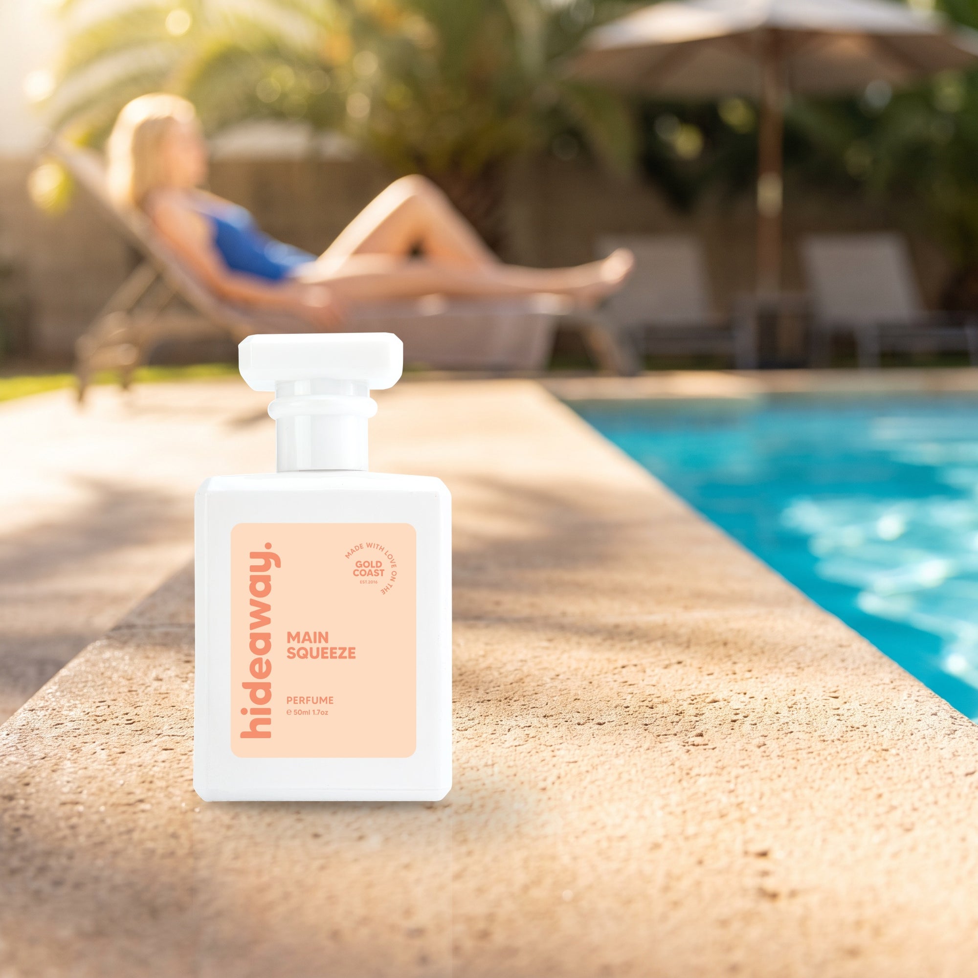 hideaway. Main Squeeze perfume 50ml bottle on a sunlit pool ledge on a summer afternoon