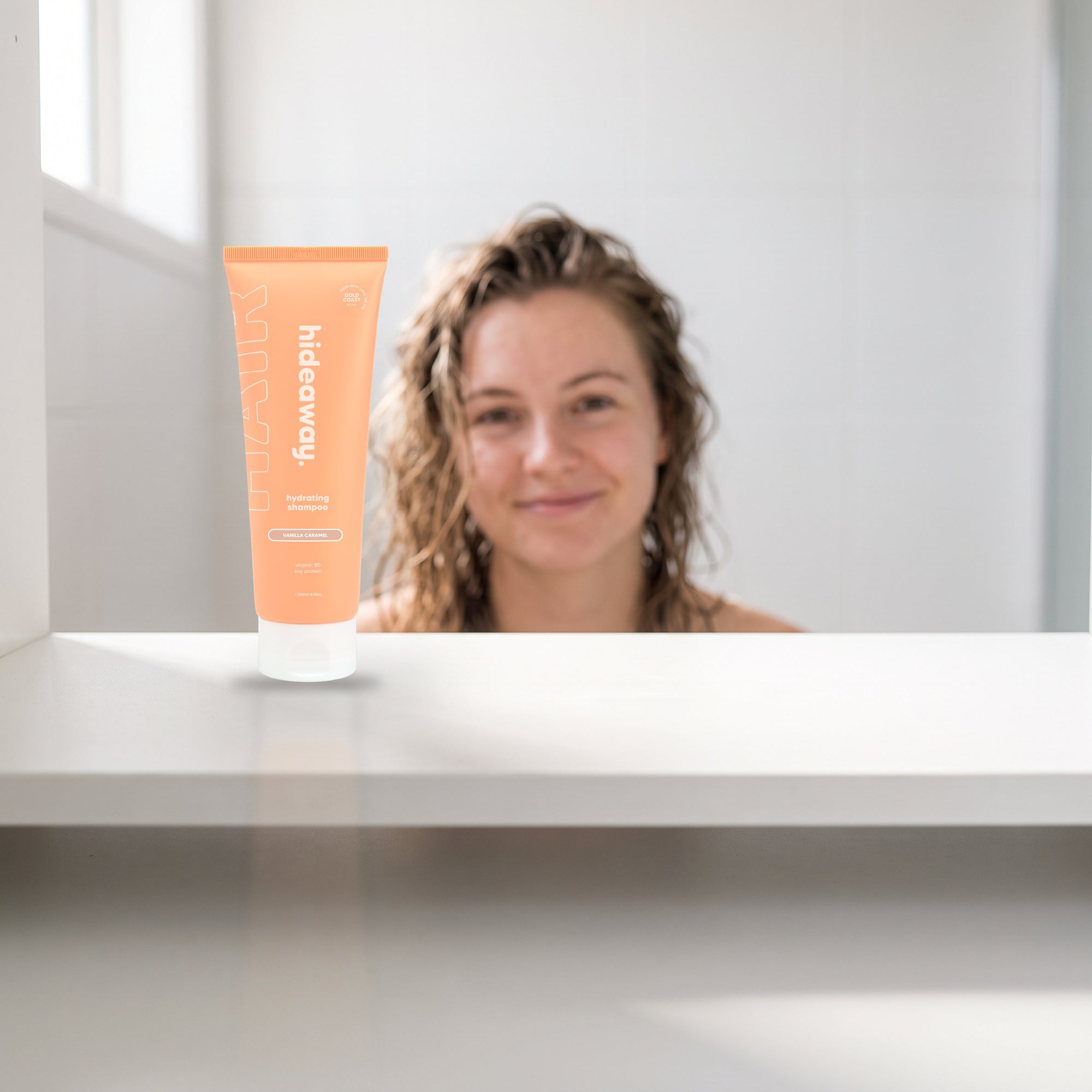 hideaway. Vanilla Caramel Shampoo on a white shelf in a bright tiled bathroom