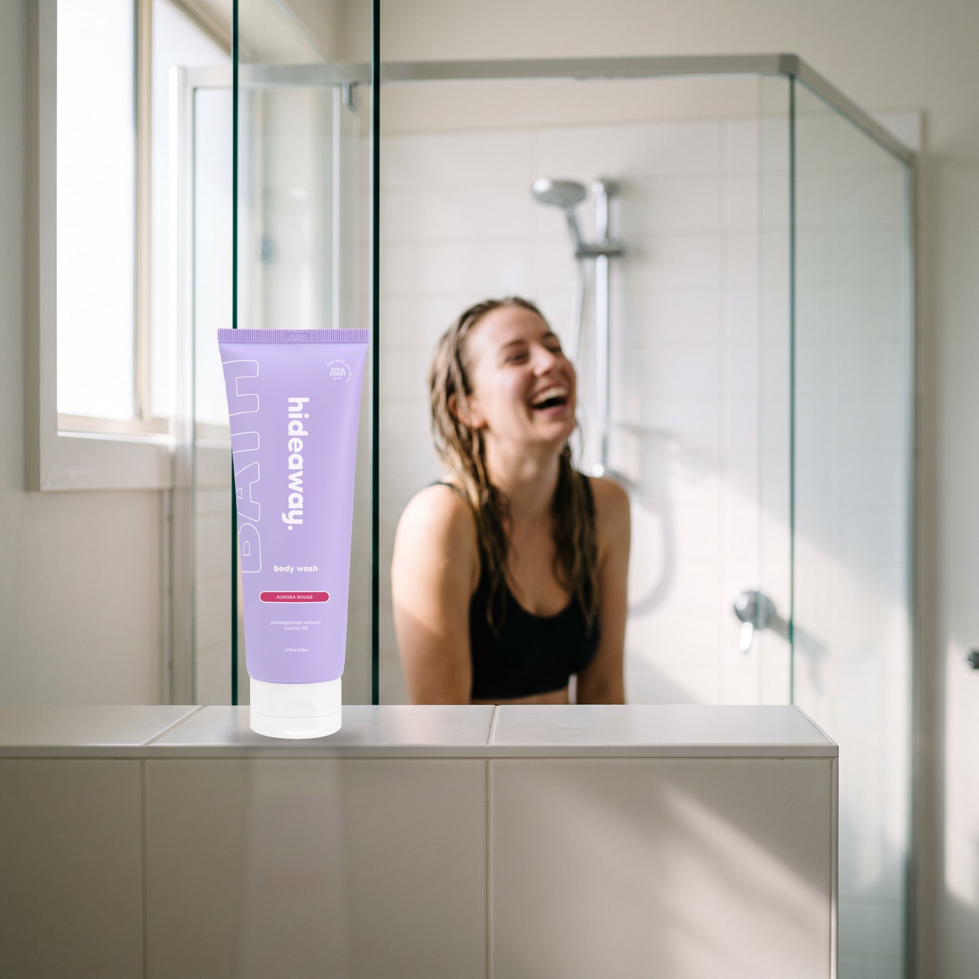 hideaway. Aurora Rouge Body Wash on a shower ledge in a bright bathroom