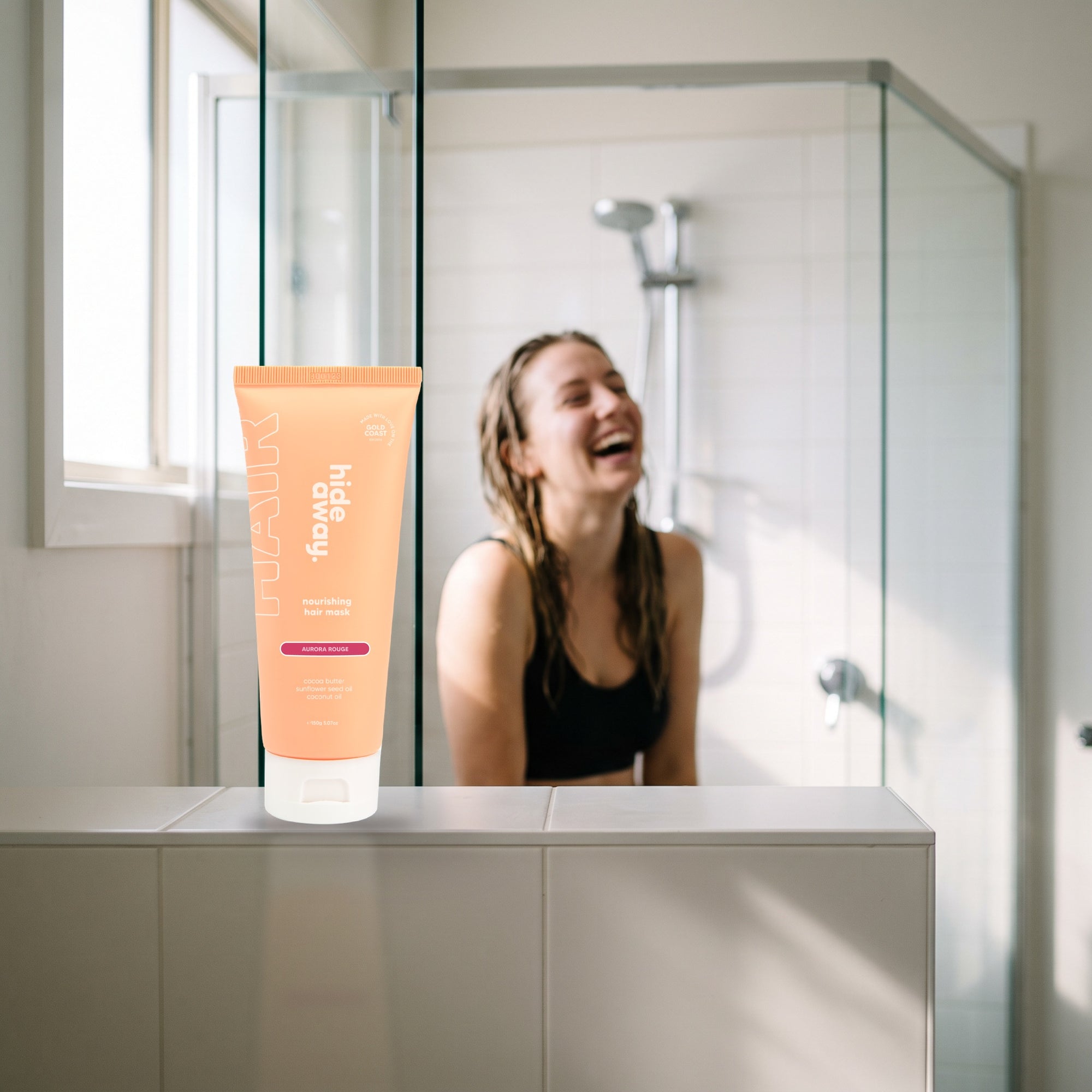 hideaway. Mini Aurora Rouge Hair Mask on a shower ledge in a bright bathroom